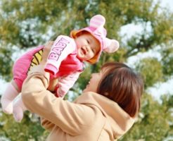 公園で抱え上げられる赤ちゃん