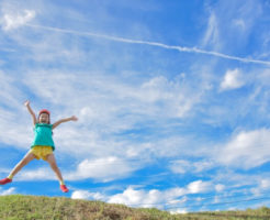 青空でジャンプする女の子