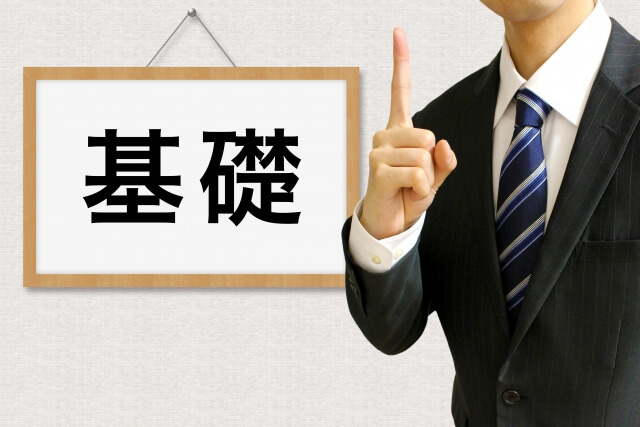 基礎の看板前に立つ学生