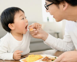 お父さんに食べさせてもらう子供